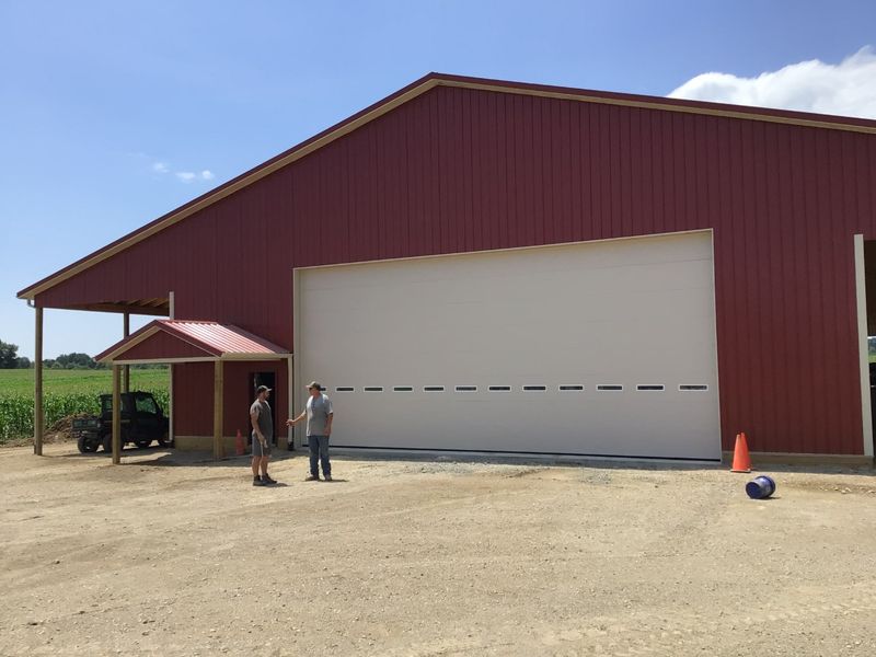 Oversized agricultural garage door on a dark red farm shop