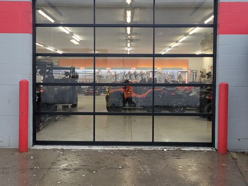 New full-view aluminum glass garage door on a powersports showroom